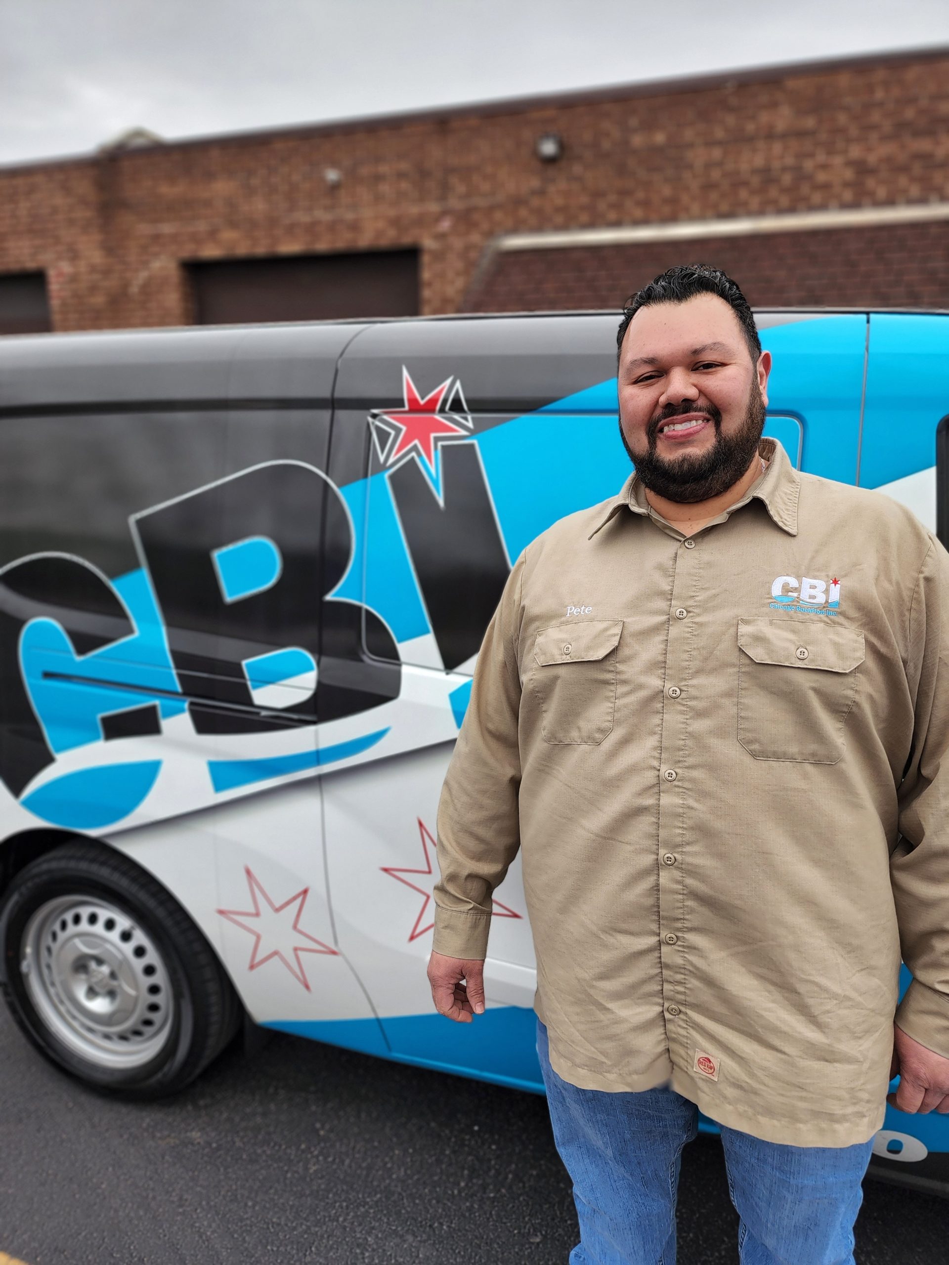 One of Chicago Backflow's professional tester next to a branded work van