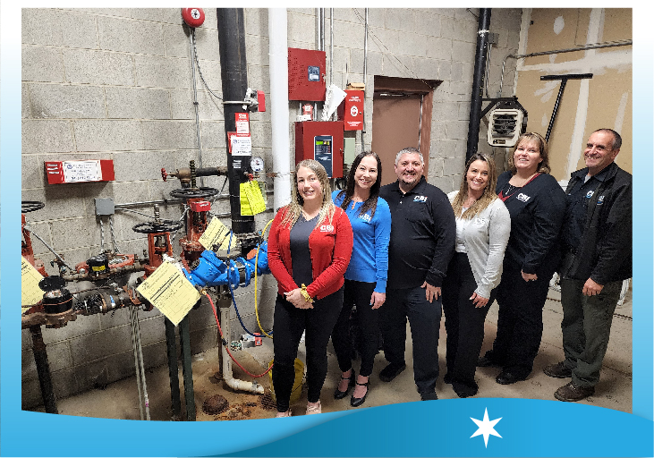 Some of Chicago Backflow's management team next to a backflow device we service